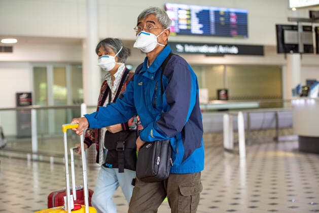 March 25, 2020, Brisbane, Australia: A couple wear face masks as a precaution against the spread of Coronavirus at Brisbane Airport..Australia and many countries are shutting borders after Covid-19 spread rapidly. Brisbane Australia - ZUMAs197 20200325_zaa_s197_024 Copyright: xFlorentxRolsx