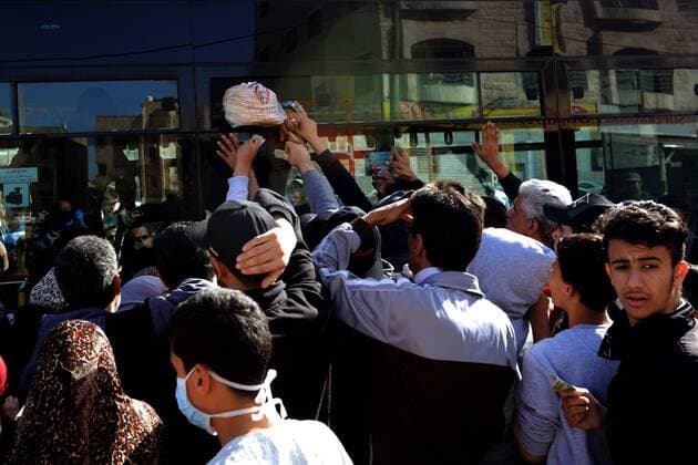 (200324) -- AMMAN, March 24, 2020 -- People buy bread in Amman, Jordan, on March 24, 2020. Jordan on Tuesday started allowing the distribution of bread, bottled water and medicine across the country, an official said on Tuesday. The number of COVID-19 cases reached 153 in the country on Tuesday. (Photo by Xinhua) JORDAN-AMMAN-COVID-19 MohammadxAbuxGhosh 