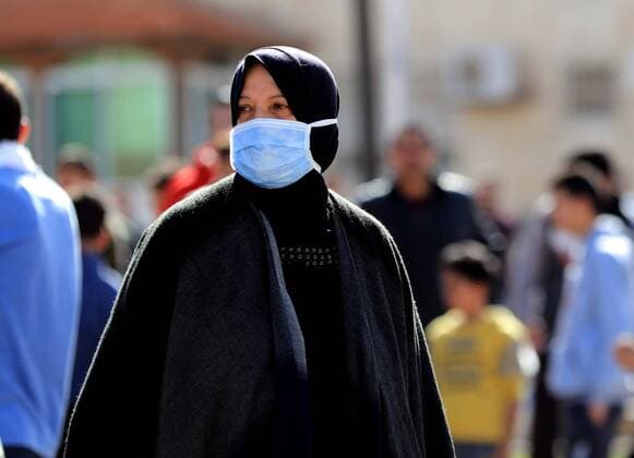 (200324) -- AMMAN, March 24, 2020 -- A woman wearing a face mask walks on a street in Amman, Jordan, on March 24, 2020. Jordan on Tuesday started allowing the distribution of bread, bottled water and medicine across the country, an official said on Tuesday. The number of COVID-19 cases reached 153 in the country on Tuesday. (Photo by Xinhua) JORDAN-AMMAN-COVID-19 MohammadxAbuxGhosh 