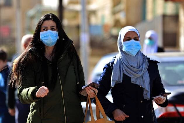 (200324) -- AMMAN, March 24, 2020 -- Women wearing face masks walk on a street in Amman, Jordan, on March 24, 2020. Jordan on Tuesday started allowing the distribution of bread, bottled water and medicine across the country, an official said on Tuesday. The number of COVID-19 cases reached 153 in the country on Tuesday. (Photo by Xinhua) JORDAN-AMMAN-COVID-19 MohammadxAbuxGhosh 