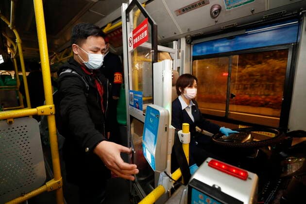 (200325) -- WUHAN, March 25, 2020 -- A passenger pays the ticket fare with a mobile phone on a bus in Wuhan, central China s Hubei Province, March 25, 2020. Wuhan, the once hardest-hit city in central China s Hubei Province during the COVID-19 outbreak, resumed a total of 117 bus routes starting Wednesday, around 30 percent of the city s total bus transport capacity, the municipal transport bureau said. According to a spokesperson of the bureau, passengers must wear masks, register with their names and scan a QR code, and take a temperature check before taking buses and subways. ) CHINA-HUBEI-WUHAN-COVID-19-BUS ROUTES-RESUMPTION (CN) ShenxBohan