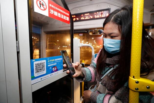 (200325) -- WUHAN, March 25, 2020 -- A passenger scans a QR code for registration on a bus in Wuhan, central China s Hubei Province, March 25, 2020. Wuhan, the once hardest-hit city in central China s Hubei Province during the COVID-19 outbreak, resumed a total of 117 bus routes starting Wednesday, around 30 percent of the city s total bus transport capacity, the municipal transport bureau said. According to a spokesperson of the bureau, passengers must wear masks, register with their names and scan a QR code, and take a temperature check before taking buses and subways. ) CHINA-HUBEI-WUHAN-COVID-19-BUS ROUTES-RESUMPTION (CN) ShenxBohan