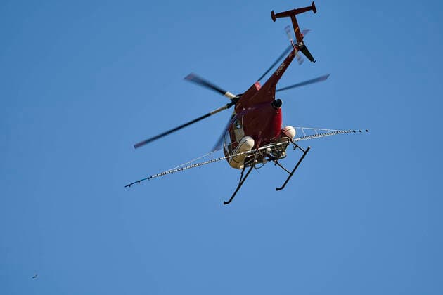 Spritzhubschrauber im Einsatz 25.03.2020, Rheinland-Pfalz, Kobern-Gondorf: Ein Spritzhubschrauber überfliegt die Weinreben nahe des Moselortes Kobern-Gondorf (Landkreis Mayen-Koblenz). Die Weinreben werden aus der Luft dabei mit Fungiziden besprühen.