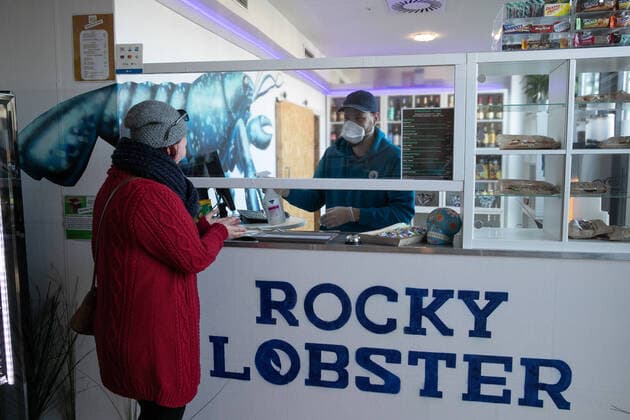 Hannover, Coronakrise, Gastronomen kämpfen ums überleben, Der Catering- Service Rocky Lobster hat in einer alten Kantine einen Streetfood-Store eröffnet, an der Kasse Lauritz Trabandt, mit Atemschutzmaske,