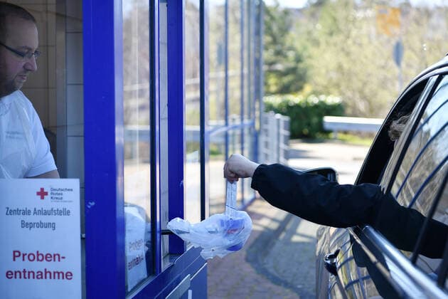 (200325) -- FRANKFURT, March 25, 2020 -- A German Red Cross healthcare worker takes a sample from a driver to test for possible coronavirus infection at a drive-through test station in Mechernich, Germany, March 24, 2020. Germany s confirmed cases of COVID-19, the disease caused by the novel coronavirus increased by 4,764 within one day to 27,436 on Tuesday, the Robert Koch Institute (RKI) announced Tuesday. So far, Germany has recorded 114 deaths as of Tuesday, according to RKI, the federal government agency and research institute responsible for disease control and prevention. Lu Yang) GERMANY-FRANKFURT-COVID-19 WuxErlixi¡¤hufunageer