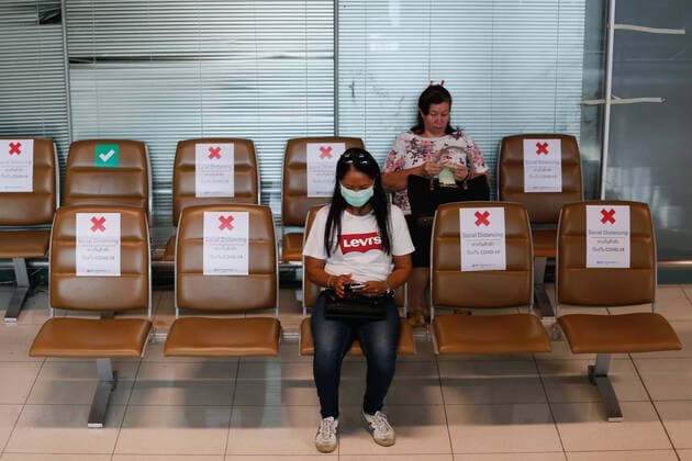 March 25, 2020, Bangkok, Thailand: A woman wearing a face mask as a precaution against the spread of Coronavirus sits in the designed chairs with signs promoting social distancing in the departures hall at Bangkok s Suvarnabhumi Airport. Bangkok Thailand - ZUMAs197 20200325_zaa_s197_058 Copyright: xChaiwatxSubprasomx