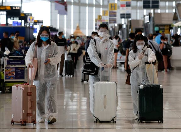 March 25, 2020, Bangkok, Thailand: Chinese tourists wearing protective suite walk pas the departures hall at Bangkok s Suvarnabhumi Airport. Bangkok Thailand - ZUMAs197 20200325_zaa_s197_063 Copyright: xChaiwatxSubprasomx