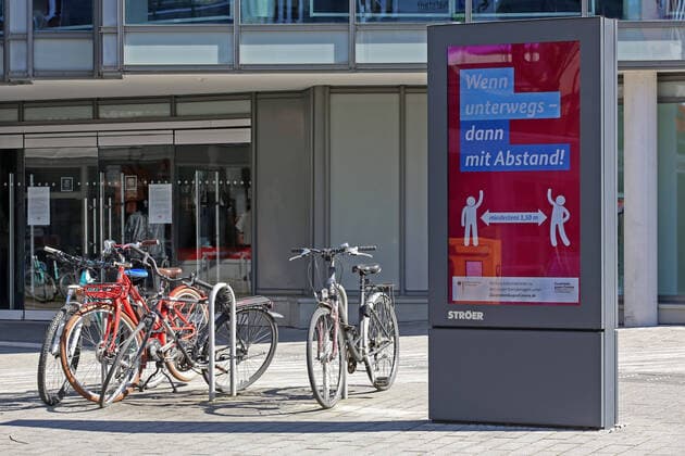 Coronavirus Angst, Auswirkungen wegen des Coronavirus (Covid-19), die Innenstadt von Siegen ist am Mittag fast leer gefegt, Ströer (Stroer) Werbescreen am Koelner (Kölner) Tor in Siegen mit Informationen zur Corona-Krise, Wenn unterwegs - dann mit Abstand! Innenstadt am 25.03.2020 in Siegen Deutschland.