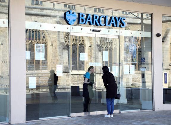 Day Two of Lockdown in Peterborough. A worker from Barclays speaks to a customer through a gap in the doors at the Barclays bank in Peterborough. The country is on lockdown due to the COVID-19 Coronavirus pandemic. People are not allowed to leave home except for minimal food shopping, medical treatment, exercise - once a day, and essential work. COVID-19 Coronavirus lockdown, Peterborough, Cambridgeshire, UK, on March 25, 2020 
