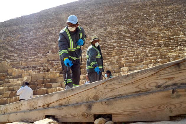 (200325) -- GIZA, March 25, 2020 (Xinhua) -- A staff member disinfects near the Pyramids in Giza, Egypt, March 25, 2020. Egypt announced on Tuesday that one COVID-19 case died and 36 new cases were detected, bringing the total number of cases in the country to 402. (Xinhua Ahmed Gomaa) EGYPT-GIZA-PYRAMIDS-DISINFECTION 