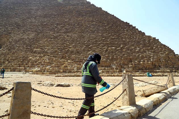 (200325) -- GIZA, March 25, 2020 (Xinhua) -- A staff member disinfects near the Pyramids in Giza, Egypt, March 25, 2020. Egypt announced on Tuesday that one COVID-19 case died and 36 new cases were detected, bringing the total number of cases in the country to 402. (Xinhua Ahmed Gomaa) EGYPT-GIZA-PYRAMIDS-DISINFECTION 