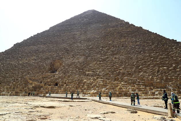 (200325) -- GIZA, March 25, 2020 (Xinhua) -- Staff members clean near the Pyramids in Giza, Egypt, March 25, 2020. Egypt announced on Tuesday that one COVID-19 case died and 36 new cases were detected, bringing the total number of cases in the country to 402. (Xinhua Ahmed Gomaa) EGYPT-GIZA-PYRAMIDS-DISINFECTION 