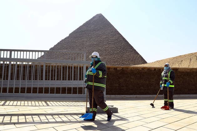 (200325) -- GIZA, March 25, 2020 (Xinhua) -- Staff members clean near the Pyramids in Giza, Egypt, March 25, 2020. Egypt announced on Tuesday that one COVID-19 case died and 36 new cases were detected, bringing the total number of cases in the country to 402. (Xinhua Ahmed Gomaa) EGYPT-GIZA-PYRAMIDS-DISINFECTION 
