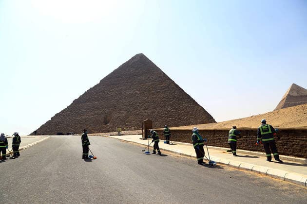 (200325) -- GIZA, March 25, 2020 (Xinhua) -- Staff members clean near the Pyramids in Giza, Egypt, March 25, 2020. Egypt announced on Tuesday that one COVID-19 case died and 36 new cases were detected, bringing the total number of cases in the country to 402. (Xinhua Ahmed Gomaa) EGYPT-GIZA-PYRAMIDS-DISINFECTION 