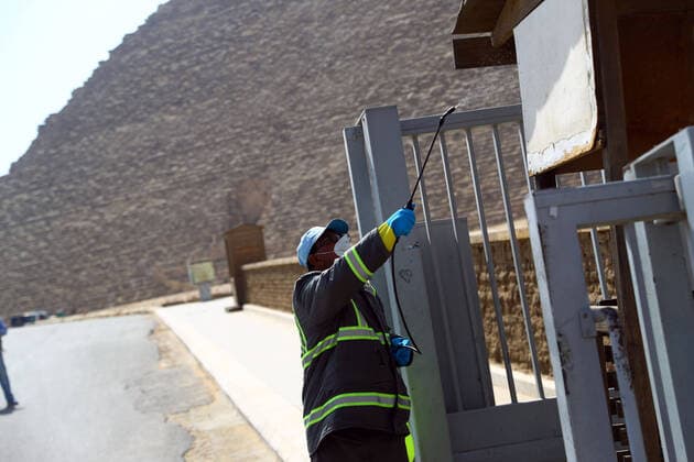 (200325) -- GIZA, March 25, 2020 (Xinhua) -- A staff member disinfects near the Pyramids in Giza, Egypt, March 25, 2020. Egypt announced on Tuesday that one COVID-19 case died and 36 new cases were detected, bringing the total number of cases in the country to 402. (Xinhua Ahmed Gomaa) EGYPT-GIZA-PYRAMIDS-DISINFECTION 