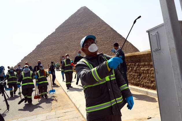 (200325) -- GIZA, March 25, 2020 (Xinhua) -- A staff member disinfects near the Pyramids in Giza, Egypt, March 25, 2020. Egypt announced on Tuesday that one COVID-19 case died and 36 new cases were detected, bringing the total number of cases in the country to 402. (Xinhua Ahmed Gomaa) EGYPT-GIZA-PYRAMIDS-DISINFECTION 