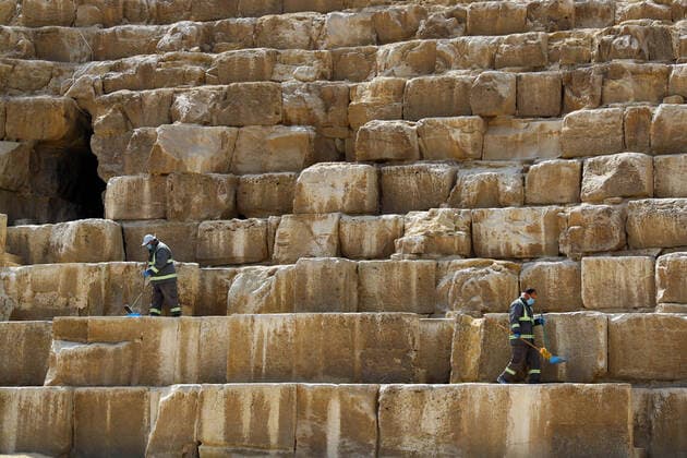 (200325) -- GIZA, March 25, 2020 (Xinhua) -- Staff members clean the Pyramids in Giza, Egypt, March 25, 2020. Egypt announced on Tuesday that one COVID-19 case died and 36 new cases were detected, bringing the total number of cases in the country to 402. (Xinhua Ahmed Gomaa) EGYPT-GIZA-PYRAMIDS-DISINFECTION 