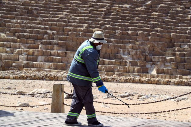 (200325) -- GIZA, March 25, 2020 (Xinhua) -- A staff member disinfects near the Pyramids in Giza, Egypt, March 25, 2020. Egypt announced on Tuesday that one COVID-19 case died and 36 new cases were detected, bringing the total number of cases in the country to 402. (Xinhua Ahmed Gomaa) EGYPT-GIZA-PYRAMIDS-DISINFECTION 