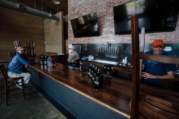March 21, 2020, Mobile, Alabama, U.S: A lone customer sits at a near empty bar at the Old Majestic Brewing Company in Mobile, Alabama USA on March 21, 2020. Many bars and restaurants are closed from serving the public but are allowed to sell food and alcohol to go for curbside pick up to help prevent the spread of the Coronavirus Covid-19 outbreak. Mobile U.S. - ZUMAa14_ 20200321_zaf_a14_015 Copyright: xDanxAndersonx