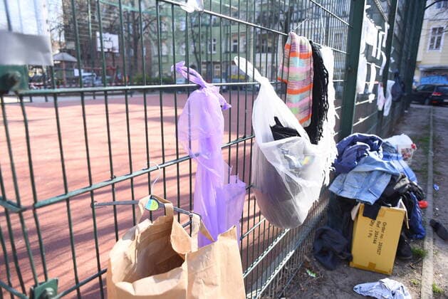Einige der Spendentüten für Obdachlos, die an diesem Zaun am Neuköllner Reuterplatz hängne, wurden bereits geleert. Gabenwand für Obdachlose