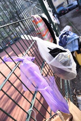Einige der Spendentüten für Obdachlos, die an diesem Zaun am Neuköllner Reuterplatz hängne, wurden bereits geleert. Gabenwand für Obdachlose