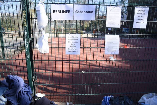 Einige der Spendentüten für Obdachlos, die an diesem Zaun am Neuköllner Reuterplatz hängne, wurden bereits geleert. Gabenwand für Obdachlose
