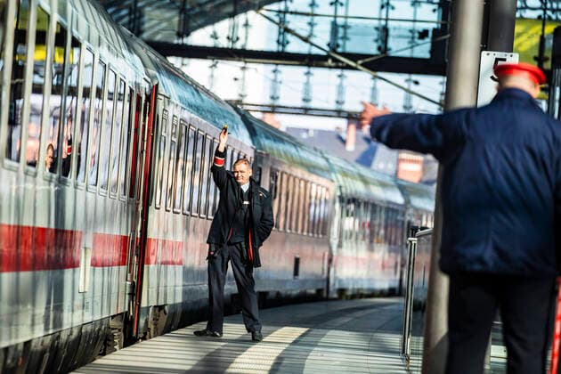Zugbegleiter und Bahnhofsvorsteher bei einem ICE Zug in Berlin am 25. Maerz 2020. Um die Verbreitung des Coronavirus (COVID-19) zu verlangsamen beschlossen Bund und Laender weitere Restriktionen. Nachdem Museen, Theatern, Sportveranstaltungen usw verboten wurden sind seit einigen Tagen Versammlungen mit mehr als zwei Personen in der Oeffentlichkeit grundsaetzlich verboten. Restaurants koennen zum Beispiel nur nich Abholung anbieten. Oeffentliches Leber weiter in Berlin wegen Coronavirus eingeschraenkt
