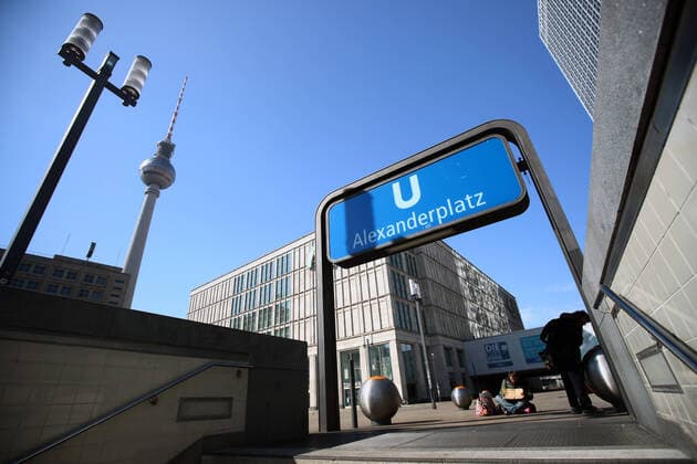 Zwei Obdachlose vor dem Ausgang der U-Bahn in einem leeren Alexanderplatz in Berlin am 25. Maerz 2020. Um die Verbreitung des Coronavirus (COVID-19) zu verlangsamen beschlossen Bund und Laender weitere Restriktionen. Nachdem Museen, Theatern, Sportveranstaltungen usw verboten wurden sind ab heute Versammlungen mit mehr als zwei Personen in der Oeffentlichkeit grundsaetzlich verboten. Obdachlose gelten als besonders schutzlos waehrend der Coronavirus-Krise. Oeffentliches Leber weiter in Berlin wegen Coronavirus eingeschraenkt