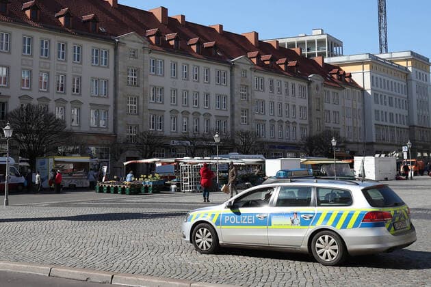 Polizei steht am Wochenmarkt auf dem Alten Markt in Magdeburg und überwacht das Markttreiben in Zeiten der Corona Krise