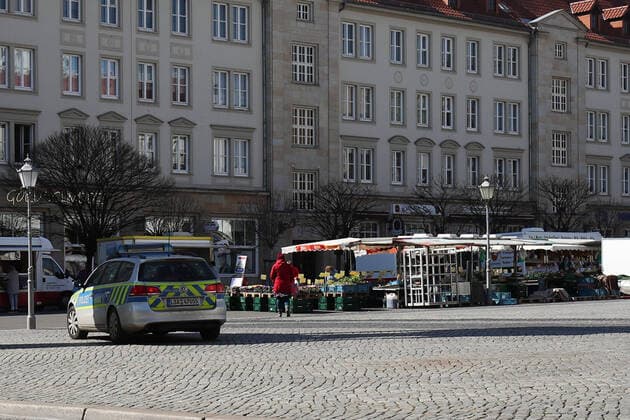 Polizei steht am Wochenmarkt auf dem Alten Markt in Magdeburg und überwacht das Markttreiben in Zeiten der Corona Krise