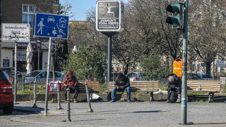 Coronavirus in Berlin Berlin, 25.03.2020, Kreuzberg. Drei Obdachlose sitzen in grossem Abstand auf Parkbaenken auf einem Platz in Kreuzberg. Waehrend der Coronakrise haben Obdachlose als Riskiogruppen mit massiven Einschraenkungen ihrer Grundversorgung und medizinischer Hilfe zu kaempfen. Berlin Berlin Deutschland Kreuzberg