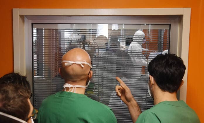 Rom 25.03.2020 Corona Krise: Pressetermin in der Intensivstation des Casal Palocco Krankenhaus; Pfleger beobachten durch ein Fenster die Intensivpfleger auf der Covid 19 Intensivstation.