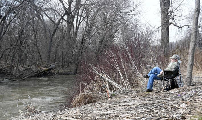 March 25, 2020, Racine, Wisconsin, USA: MIKE DECKER from nearby Sturtevant, Wisconsin tries his luck fishing in the Root River in Racine, Wisconsin, and Wednesday March 25, 2020. He alternated between casting and sitting in a chair while hoping for a bite. Racine USA - ZUMAh154 20200325_znp_h154_008 Copyright: xMarkxHertzbergx