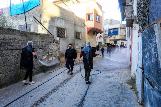 March 25, 2020, Gaza City, The Gaza Strip, Palestine: A Palestinian sprays disinfectant as a precaution against the spread of the Covid-19 coronavirus, in the streets of the Jabalia refugee camp, northern Gaza Strip, 25 March 2020. The Palestinian Ministry of Health in Gaza had confirmed on 22 March 2020 that there were two cases of novel coronavirus Covid-19 in the Gaza Strip. Gaza City Palestine - ZUMAq100 20200325_zaa_q100_058 Copyright: xMahmoudxIssax