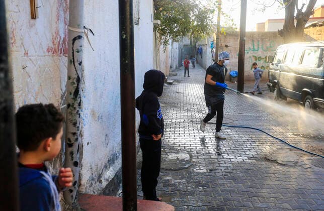 March 25, 2020, Gaza City, The Gaza Strip, Palestine: A Palestinian sprays disinfectant as a precaution against the spread of the Covid-19 coronavirus, in the streets of the Jabalia refugee camp, northern Gaza Strip, 25 March 2020. The Palestinian Ministry of Health in Gaza had confirmed on 22 March 2020 that there were two cases of novel coronavirus Covid-19 in the Gaza Strip. Gaza City Palestine - ZUMAq100 20200325_zaa_q100_060 Copyright: xMahmoudxIssax
