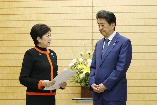 New coronavirus Tokyo Gov. Yuriko Koike (L) meets Prime Minister Shinzo Abe over the new coronavirus at his office in Tokyo on March 26, 2020, as infections surge in the capital. 