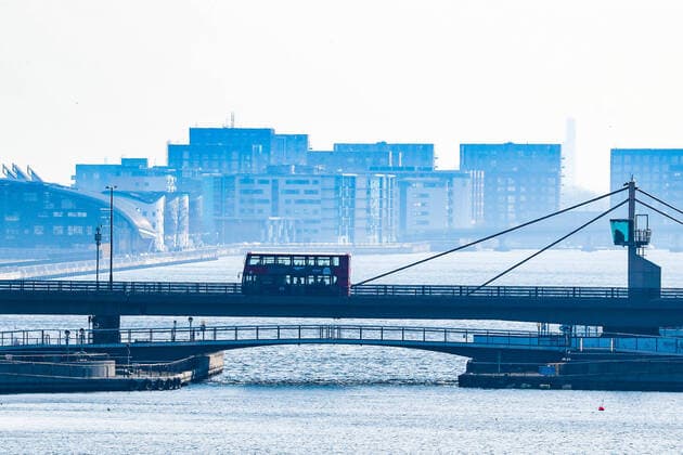 A red bus is seen driving over a Bridge near London City airport, a view taken from the Excell Center in London, Thursday, March 26, 2020. All flights from London City Airport have been cancelled as a result of the coronavirus outbreak since last night. The British Government announced Tuesday, that the ExCel Center in east London will become a 4,000-bed temporary hospital to deal with future coronavirus patients, to be called NHS Nightingale. (Photo Vudi Xhymshiti)  iMagoVX