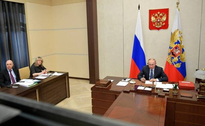 March 26, 2020. - Russia, Moscow Region, Novo-Ogaryovo. - Russian President Vladimir Putin (right) takes part in an extraordinary G20 Summit via a video link. The summit is dedicated to the COVID-19 coronavirus pandemic and is held online for the first time. Also pictured: Russian Finance Minister Anton Siluanov and Deputy Head of the Russian Presidential Experts Directorate, Russia s G20 Sherpa Svetlana Lukash (from L to R). KremlinxPool