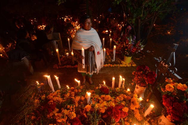 IMAGO Cultures of the world, Zapotec Kultur in Mexiko Zapotec woman holding candle among graves adorned with marigolds, Atzompa, Oaxaca, Mexico, North America Copyright: RaulxTouzon 1318-156