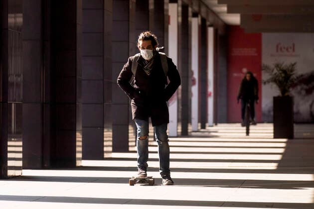 Ein Mann mit Skate und Mundschutzmaske in Berlin am 26. Maerz 2020. Um die Verbreitung des Coronavirus (SARS-CoV-2) zu verlangsamen beschlossen Bund und Laender weitere Restriktionen. Nachdem Museen, Theatern, Sportveranstaltungen usw verboten wurden sind seit einigen Tagen weitere verschaerfte Massnahmen in Kraft getreten wie z.B. Verbot von Versammlungen in der Oeffentlichkeit mit mehr als zwei Personen, Einhaltung von Mindestabstand zwischen Personen und Schliessung von Gastronomiebetrieben mit Ausnahme vn Abholung und Lieferung. Oeffentliches Leber weiter in Berlin wegen Coronavirus eingeschraenkt