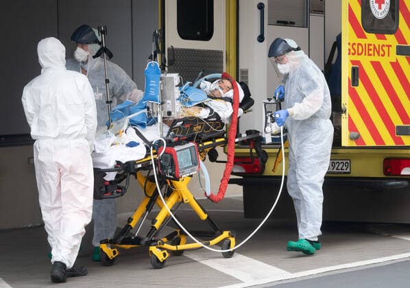 Corona-Patient aus Italien Notfallmediziner in Schutzkleidung aus dem Uniklinikum Dresden bringen einen italienischen Corona Patienten aus einem Intensiv-Transportwagen in die Intensivstation des Uniklinikums Dresden. Vorher waren die zwei italienischen Corona Patienten mit einer Militärmaschine auf dem Dresdner Flughafen gelandet und von dort mit einem Intensiv-Transportwagen abgeholt worden.