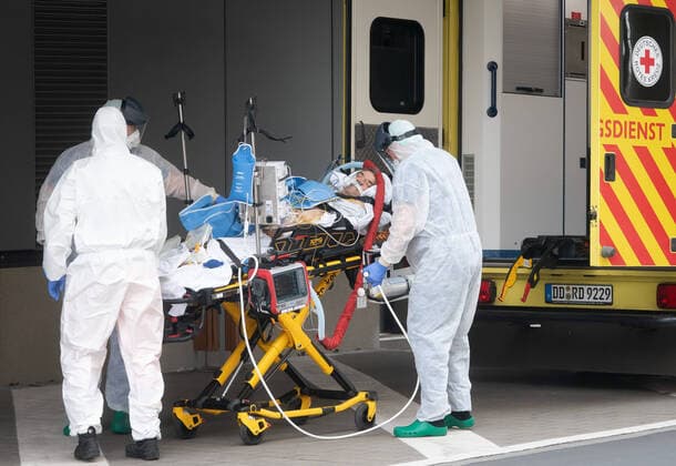 Corona-Patient aus Italien Notfallmediziner in Schutzkleidung aus dem Uniklinikum Dresden bringen einen italienischen Corona Patienten aus einem Intensiv-Transportwagen in die Intensivstation des Uniklinikums Dresden. Vorher waren die zwei italienischen Corona Patienten mit einer Militärmaschine auf dem Dresdner Flughafen gelandet und von dort mit einem Intensiv-Transportwagen abgeholt worden.