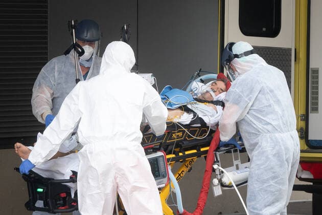 Corona-Patient aus Italien Notfallmediziner in Schutzkleidung aus dem Uniklinikum Dresden bringen einen italienischen Corona Patienten aus einem Intensiv-Transportwagen in die Intensivstation des Uniklinikums Dresden. Vorher waren die zwei italienischen Corona Patienten mit einer Militärmaschine auf dem Dresdner Flughafen gelandet und von dort mit einem Intensiv-Transportwagen abgeholt worden.