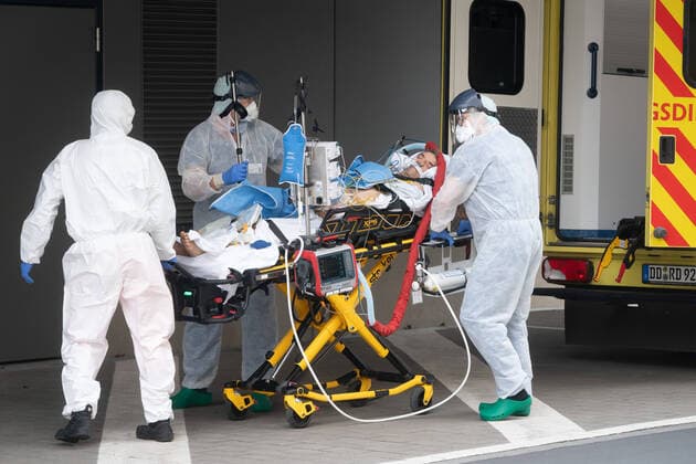 Corona-Patient aus Italien Notfallmediziner in Schutzkleidung aus dem Uniklinikum Dresden bringen einen italienischen Corona Patienten aus einem Intensiv-Transportwagen in die Intensivstation des Uniklinikums Dresden. Vorher waren die zwei italienischen Corona Patienten mit einer Militärmaschine auf dem Dresdner Flughafen gelandet und von dort mit einem Intensiv-Transportwagen abgeholt worden.