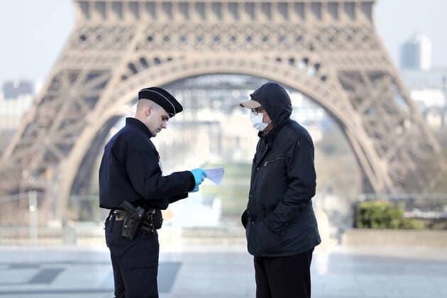 Security forces keep their distances to protect themselves from a potential infection as they check residents for the documents allowing them to be in the streets of Paris, France, Thursday, March 26, 2020. French authorities tightened lockdown rules on physical exercise today limiting outings to one hour maximum as the coronavirus epidemic continues to spread in the country with 1,331 dead, including 186 in past 24 hours.  PAR20200326107 ECOxCLEMENT
