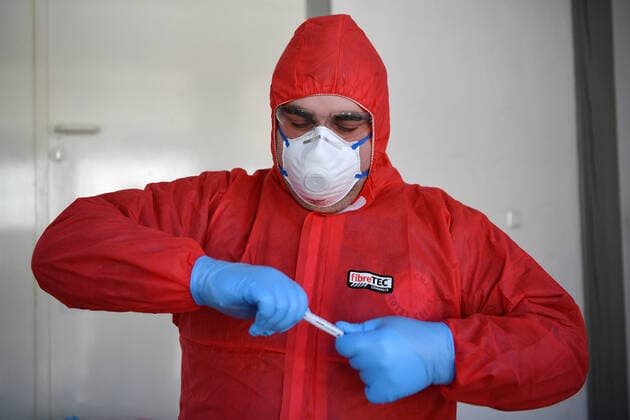 (200326) -- LENNESTADT (GERMANY), March 26, 2020 (Xinhua) -- A healthcare worker observes a test kit after taking a sample from a driver to test for possible COVID-19 infection at a drive-through test station in Lennestadt, Germany, on March 26, 2020. Confirmed cases of COVID-19 in Germany increased by 4,954 within one day to 36,508, the Robert Koch Institute (RKI) announced on Thursday. The number of deaths from COVID-19 increased from 149 to 198, according to RKI, the federal government agency and research institute responsible for disease control and prevention. (Photo by Ulrich Hufnagel Xinhua) GERMANY-LENNESTADT-COVID-19-DRIVE-THROUGH TEST 
