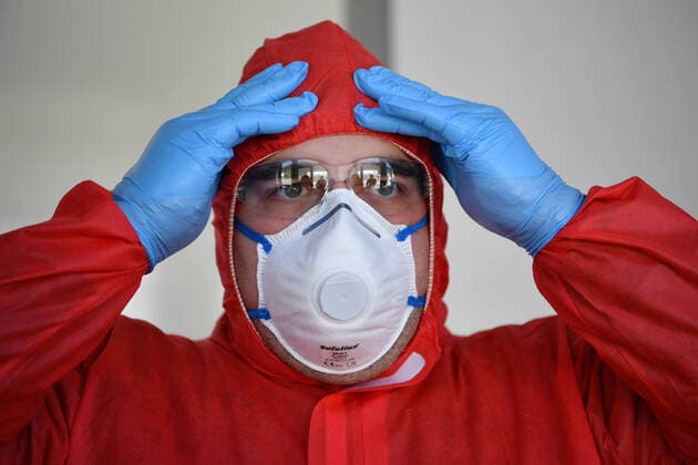 (200326) -- LENNESTADT (GERMANY), March 26, 2020 (Xinhua) -- A healthcare worker checks his protective clothing before taking samples from drivers to test for possible COVID-19 infection at a drive-through test station in Lennestadt, Germany, on March 26, 2020. Confirmed cases of COVID-19 in Germany increased by 4,954 within one day to 36,508, the Robert Koch Institute (RKI) announced on Thursday. The number of deaths from COVID-19 increased from 149 to 198, according to RKI, the federal government agency and research institute responsible for disease control and prevention. (Photo by Ulrich Hufnagel Xinhua) GERMANY-LENNESTADT-COVID-19-DRIVE-THROUGH TEST 