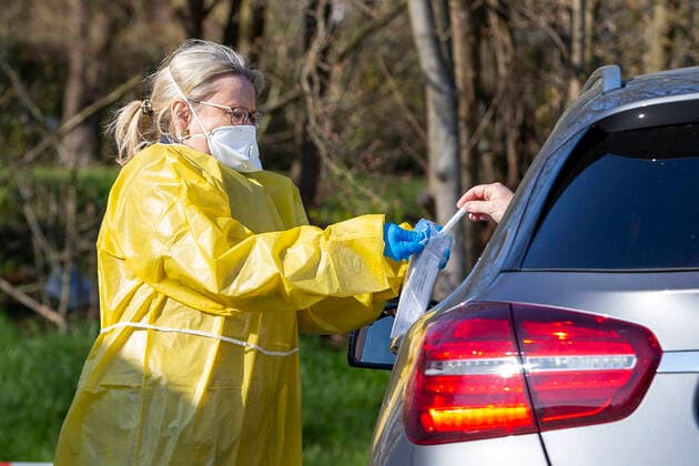 (200326) -- ISERLOHN (GERMANY), March 26, 2020 (Xinhua) -- A healthcare worker takes a sample from a driver to test for possible COVID-19 infection at a drive-through test station in Iserlohn, Germany, on March 26, 2020. Confirmed cases of COVID-19 in Germany increased by 4,954 within one day to 36,508, the Robert Koch Institute (RKI) announced on Thursday. The number of deaths from COVID-19 increased from 149 to 198, according to RKI, the federal government agency and research institute responsible for disease control and prevention. (Photo by Joachim Bywaletz Xinhua) GERMANY-ISERLOHN-COVID-19-DRIVE-THROUGH TEST