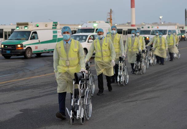 (200326) -- FARWANIYA GOVERNORATE (KUWAIT), March 26, 2020 (Xinhua) -- Medical workers and ambulances wait for the arrival of planes carrying Kuwaiti citizens evacuated from abroad at Kuwait International Airport in Farwaniya Governorate, Kuwait, on March 26, 2020. Kuwait reported 13 new COVID-19 cases over the past 24 hours, bringing the total number of confirmed cases in the country to 208, the Health Ministry announced Thursday. (Photo by Asad Xinhua) KUWAIT-FARWANIYA GOVERNORATE-COVID-19-MEASURES 