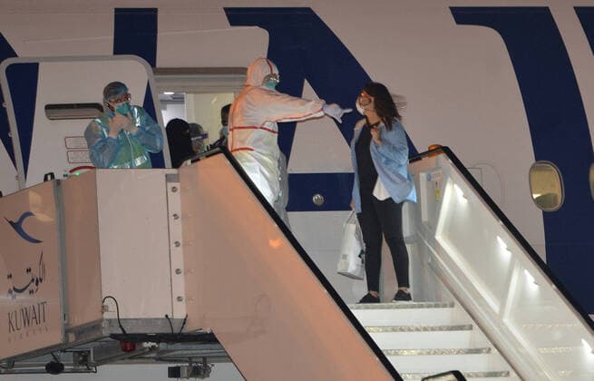 (200326) -- FARWANIYA GOVERNORATE (KUWAIT), March 26, 2020 (Xinhua) -- Kuwaiti citizens evacuated from abroad disembark from a plane at Kuwait International Airport in Farwaniya Governorate, Kuwait, on March 26, 2020. Kuwait reported 13 new COVID-19 cases over the past 24 hours, bringing the total number of confirmed cases in the country to 208, the Health Ministry announced Thursday. (Photo by Asad Xinhua) KUWAIT-FARWANIYA GOVERNORATE-COVID-19-MEASURES 